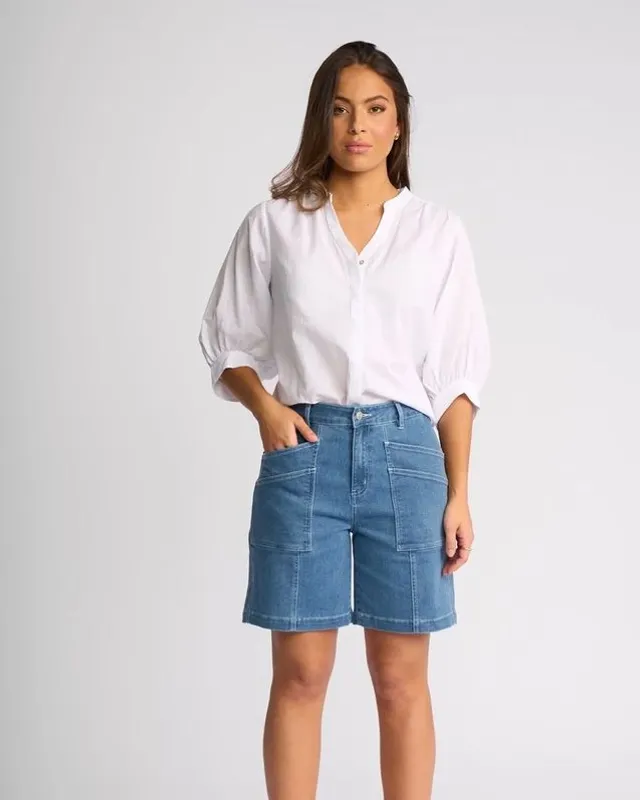 Model in a white shirt and denim shorts