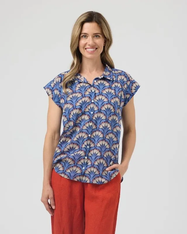Model in a blue printed top and red trousers